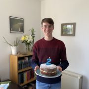 Man smiling holding cake