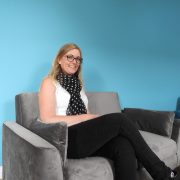 Woman sitting on couch blue background